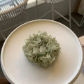 Close-up of light green pleated scrunchie with ruffled organza texture on white plate - Mesh Scrunchie / Olive Green