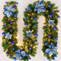 Guirnalda navideña clásica con ramas de pino verde, flores azules y luces LED cálidas - 1.8m / Ratán Azul (con luces)
