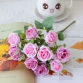 Detailed view of pink silk roses with green leaves on an open magazine in cozy setting - Red Lotus