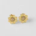 Détail de boucles d'oreilles tournesol dorées avec zircons et pétales finement gravés - Style Tournesol