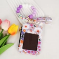 Detail of floral wallet keychain with purple silicone bead wristlet and tassel accent - Purple Floral