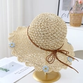 Détail d'un chapeau en paille avec broderies florales bleues et noeud sur support - Beige avec petites fleurs bleues