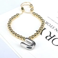Detail of adjustable gold beaded bracelet with silver balloon-style letter U charm - Letter U