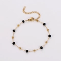 Detail eines Goldarmbands mit schwarzen Facettenperlen, Karabiner und Verlängerungskette - 4mm-Armband
