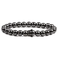 Macro detail of natural black hematite beaded bracelet featuring a vintage crown charm - Gun Black Crown