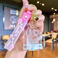 Pink castle quicksand keychain with silicone strap and golden bell charm detail - White Luminous Bubble Bead Castle