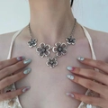 Bohemian silver floral statement necklace with vintage metallic flowers on a female model - Bohemian Peach Blossom Metal Necklace