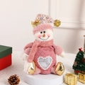 Pink snowman Christmas gift bag with heart window and festive decor on white pedestal - Snowman