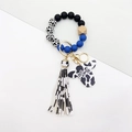 Dettaglio del portachiavi a bracciale western con perline blu e nappa stampa mucca - Blu