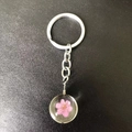 Handmade silver keychain with pink dried flower inside a transparent resin globe - Pink Plum Blossom