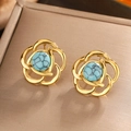 Detailed macro view of vintage flower stud earrings with turquoise stones in gold frames - Gold / Lake Blue Turquoise