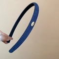 Détail d'un serre-tête bleu marine floqué avec une boucle dorée gravée 'Love' élégante - Bleu foncé