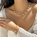 Detailed view of a gold starfish necklace and bracelet set on a female model - Starfish Necklace and Bracelet Set