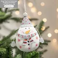 Hand-painted snowman Christmas ornament in red and white hanging on a festive tree - Style D / Large Snowman