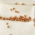 Vista macro di perline metalliche sfaccettate in oro rosa per gioielli fai da te - Diametro 2.5mm Foro Circa 1.0mm / Oro rosa