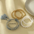 Set de pulseras estilo playa con cuentas doradas, perlas y borla tejida Believe - Juego de Pulseras Apiladas (Letra BELIEVE)