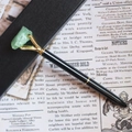 Stylo à bille en métal noir avec griffe dorée sertie d'une pierre de cristal vert - Fluorite
