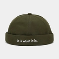 Close-up of dark green docker hat with it is what it is white letter embroidery - Adjustable / Army Green