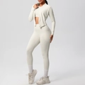 Detailansicht des cremefarbenen Yoga-Sets mit Zip-Jacke und Leggings mit praktischer Seitentasche - Helles Elfenbein