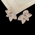Macro detail of silver layered petal earrings with irregular textured metallic surface - Silver