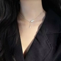 Close-up of elegant gold necklace featuring a white feather charm and teardrop zircon pendant - Angel Wings Necklace