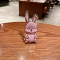 Detalle del soporte metálico de conejo rosa para móvil con bordes dorados y esmalte - Morado