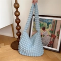 Hellblaue Hobo-Tasche mit Blasenstruktur und breitem Plisseegurt in künstlerischem Ambiente - Blasen-Blau