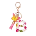 Portachiavi lettera B in resina con nappa rosa e ciondolo a farfalla su bianco - Fiore B