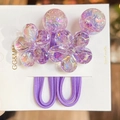 Close-up of purple camellia hair ties with holographic flower and bead details - Violet