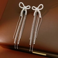 Dettaglio di orecchini a fiocco d'argento con nappe lunghe e zirconi scintillanti - Perno Argento Argento / Argento