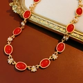 Dettaglio di gemme in resina rossa vintage e perle su una catena dorata con fiori - Collana (Oro-Rosso)
