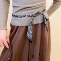 Detail of vintage paisley pattern scarf belt with pearl beads on a neutral outfit - White Retro Paisley Waist Belt