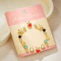Mix of 7 stylish gold studs including pearls, stars and red hearts on jewelry card - Gold Starfish Strawberry (E1896-1)