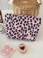 Dettaglio macro della borsa da trucco leopardata con cerniera e etichetta in tessuto - rosa acceso