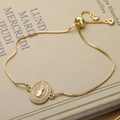 Adjustable gold Virgin Mary bracelet with zircon inlay and sliding ball clasp on vintage book - 31320/Oval Virgin Mary Medal