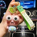 Pink monster keychain with blue vest, green silicone strap, and BOOM tag detail - Stress Relief Pop-Eye Frog / Pink