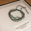 Close-up of bohemian multi-layer beaded bracelet with green cord and star charms - 23# Bracelet-Green