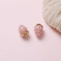 Detail of two pink strawberry pendants with gold leaf hooks on a soft pink background - Pink