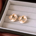 Vue macro de boucles d'oreilles spirales plaquées or 14K avec détails pavés en diamant - Doré