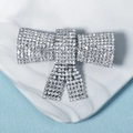 Elegant silver metal bow hairpin with sparkling rhinestones on marble and blue texture - Bowknot