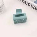 Macro di una molletta quadrata per capelli verde grigio opaco con texture gommata - 5cm / Azzurro