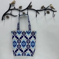 Blue and white Ikat pattern canvas tote bag hanging on a bird-shaped metal hook - Azure Blue