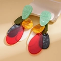 Detailed close-up of acrylic teardrop earrings with colorful marble texture on stone - Colorful