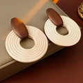 Nahaufnahme von geometrischen Holzohrringen mit braun-beigem Spleißdesign-Detail - Silbernadel Kaffee Originalholz