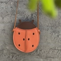 Detail view of ladybug-shaped kids leather bag with litchi texture and orange finish - Ladybug Red