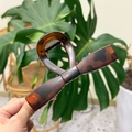 Detail of a large dark brown tortoiseshell hair claw clip with a sleek bow-shaped design - XL Straight Bow (13.5cm) / Matte Red Brown