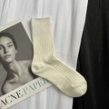 Off-white ribbed cotton mid-calf socks displayed on a minimalist magazine background - Short White