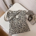 Detail of leopard print canvas tote bag with stitched fabric patch and long shoulder strap - Black and White Leopard Print