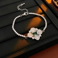 Close-up of silver bracelet featuring a flower pendant with emerald green square stone - Silver Green Bracelet