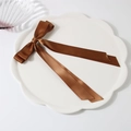Barrette à nœud en satin marron foncé avec de longs rubans sur un plateau blanc - Chocolat